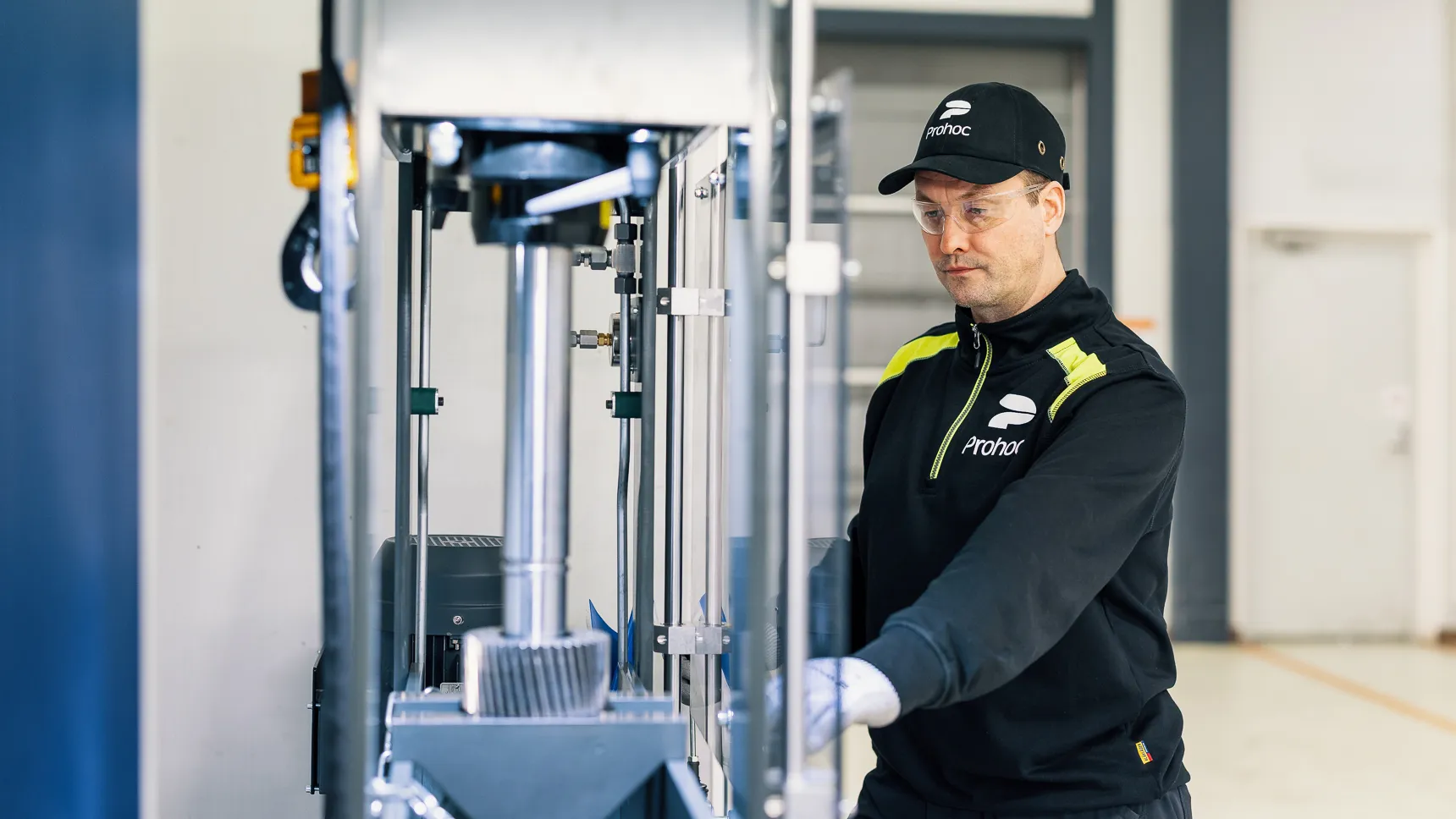 Person arbetar vid maskinutrustning i industri- och logistikmiljö