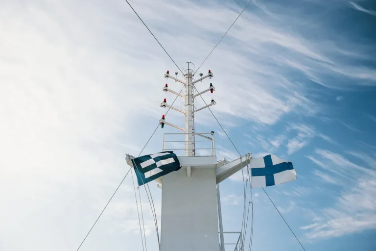 Flaggor på fartyg mot blå himmel.