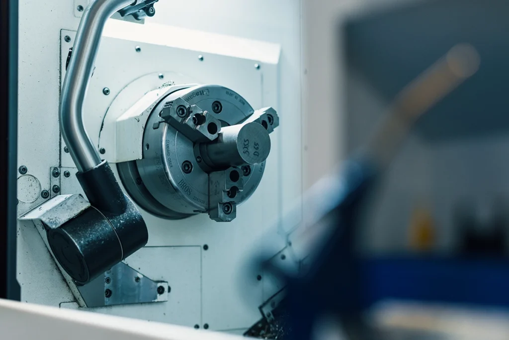 Metallämne fastspänt i en CNC-svarv hos Chips Metals.